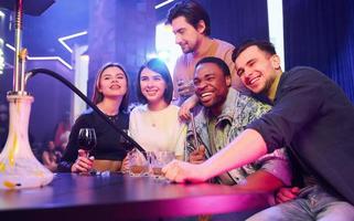 Positive emotions. Group of friends having fun in the night club together photo