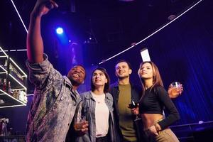 tiempo de fiesta. grupo de amigos divirtiéndose juntos en la discoteca foto