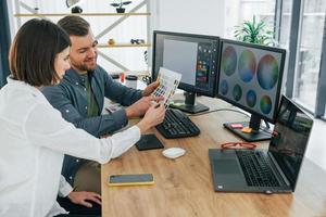 elegir los colores correctos. dos diseñadores trabajando juntos en la oficina foto