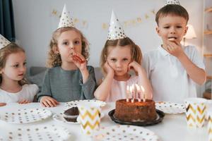 celebrando el cumpleaños. grupo de niños está juntos en casa durante el día foto