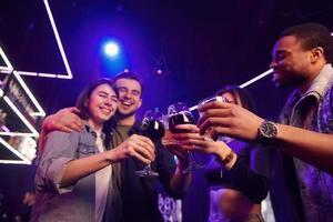 gente haciendo vítores. grupo de amigos divirtiéndose juntos en la discoteca foto