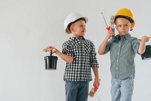 Cheerful kids. Two boys painting walls in the domestic room photo