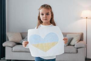 niña sosteniendo una pancarta con una imagen de calor en el color de la bandera ucraniana foto