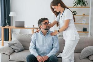 Working with mature man. Professional nurse is in white coat is in the office photo