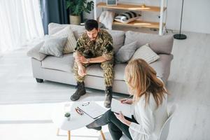 Having conversation. Soldier have therapy session with psychologist indoors photo