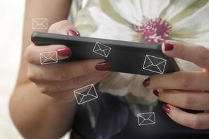 Woman with smartphone writing emails or reading newsletter photo