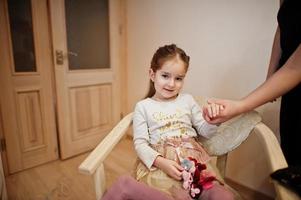 Mom making hairstyle, girl with hairpins. photo