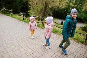 Brother with sisters walking at park. photo