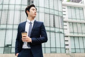 Image of Young asian businessman with glass building background photo