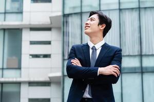 Image of Young asian businessman with glass building background photo