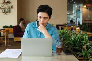 Asian man sitting and drinking coffee photo