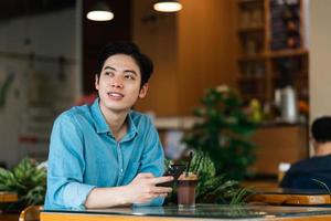 Asian man sitting and drinking coffee photo