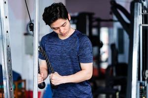 Young man in sportswear exercising at the gym photo