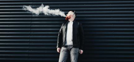 man exhales cloud of smoke photo