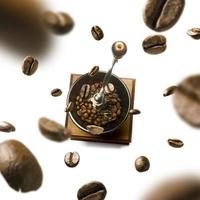 Coffee grinder and coffee beans in flight on white background photo