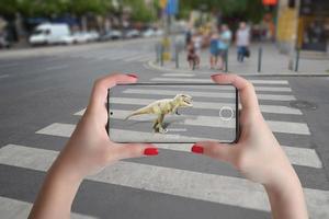 proyección 3d de dinosaurios en la calle con teléfono inteligente y concepto de tecnología de realidad aumentada foto