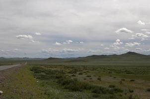 Beautiful mongolian landscape. Road at the left side, with only one car photo