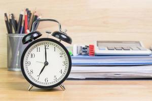 7 am reloj en el escritorio de trabajo en el tiempo de oficina del hombre de negocios conceptos de trabajo reloj selectivo foto