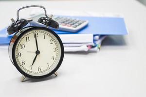 7 am reloj en el escritorio de trabajo en el tiempo de oficina del hombre de negocios conceptos de trabajo reloj selectivo foto