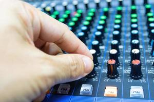 manos de hombres están controlando la consola de un gran sistema de alta fidelidad. equipo de sonido. panel de control de un estudio digital foto