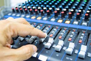 manos de hombres están controlando la consola de un gran sistema de alta fidelidad. equipo de sonido. panel de control de un estudio digital foto