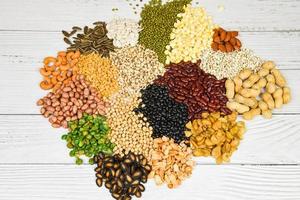 conjunto de diferentes granos enteros frijoles y legumbres semillas lentejas y nueces colorido fondo de textura de refrigerio - varios frijoles mezclan guisantes agricultura de alimentos naturales saludables para cocinar ingredientes foto