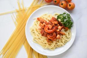 espaguetis a la boloñesa pasta italiana con camarones camarones servidos en un plato blanco con tomate perejil en el restaurante comida italiana y concepto de menú espaguetis mariscos foto