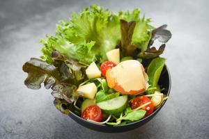 ensalada de verduras con huevo - ensalada con fruta y lechuga fresca tomate pepino en un tazón en la mesa concepto de alimentación saludable foto