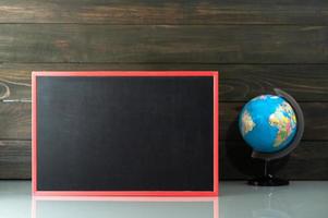 Chalkboard mock up frame and globe model on table photo