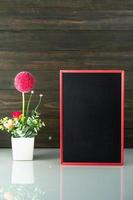 Flower vase and blank chalkboard on table photo