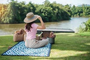 Happy Woman with hat in picnic time in the park near river, Summer, spring and vacation concept photo