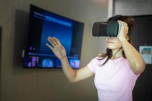 Young woman using virtual reality headset. VR, Future digital technology, game, movies entertainment, metaverse, NFT and 3D cyberspace concept photo