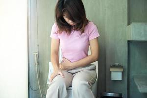 Woman sit on toilet bowl. diarrhea, constipated period, infection, abdominal, stomachache, cystitis, Insurance and Medical concept photo