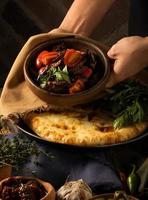 una toma vertical de un chef que sirve un plato de ensalada gourmet foto