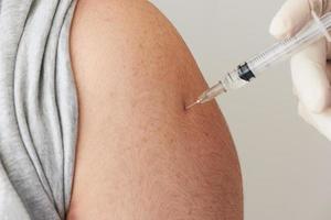 A doctor injecting  vaccine at patient arm photo