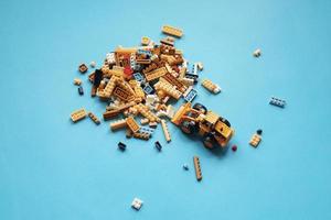 Group of plastic toys and bulldozer on blue background. photo