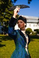 Portrait of woman dressed in blue historical Baroque clothes with old fashion hairstyle, outdoors. photo