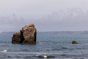 Thurlestone Rock arched natural rock formation lying just off the rocks at one end of the beach photo