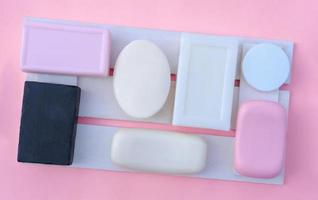 pink, white and black soap bars on a wooden tray photo