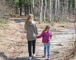 curly sisters cuddling while walking in the forest. photo