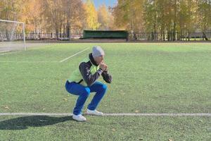 handsome caucasian man doing squats on a stadium football field photo