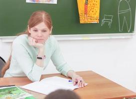 hermosa joven profesora pensando en algo en clase. foto