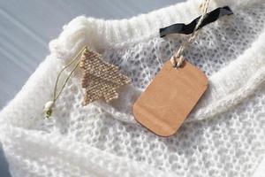 white knitted pullover with wooden tag mockup photo