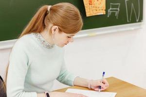 young beautiful woman writing with left hand. photo