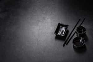 Wooden sushi sticks on a dark concrete background photo