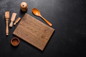 An empty wooden cutting board with wooden cutlery