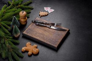 An empty wooden cutting board with wooden cutlery on a christmas kitchen table photo