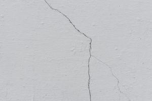 Texture of a concrete wall with cracks and scratches which can be used as a background photo