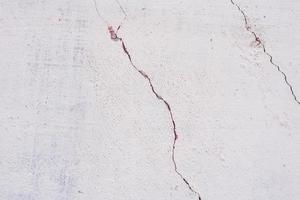 Texture of a concrete wall with cracks and scratches which can be used as a background photo