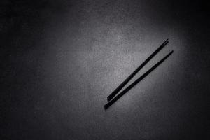 Wooden sushi sticks on a dark concrete background photo